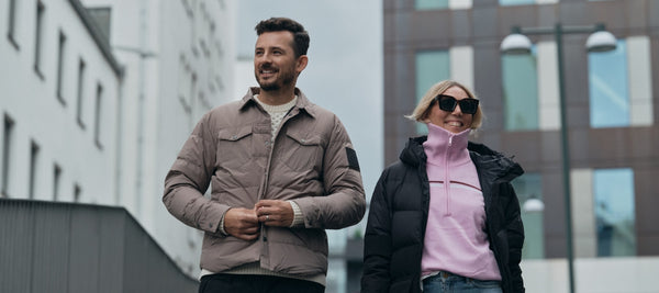 Man and woman waking on the street in autumn jackets and sweaters.